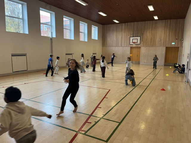 Børn der løber i en gymnastiksal