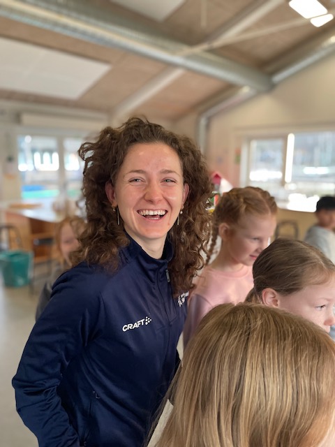 Ida Sand Pedersen i stort smil leger med børn