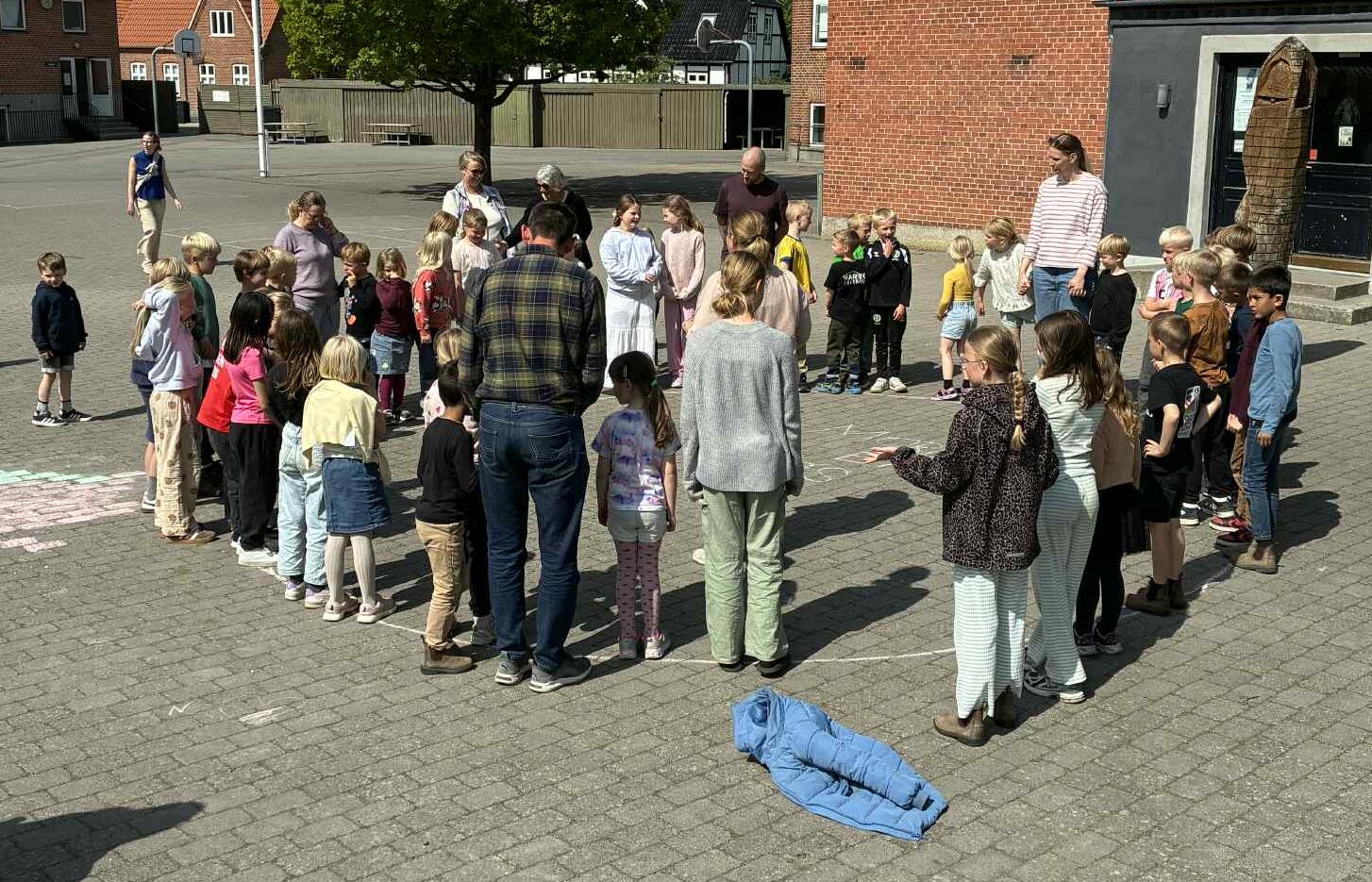 Børn og voksne i en skolegård